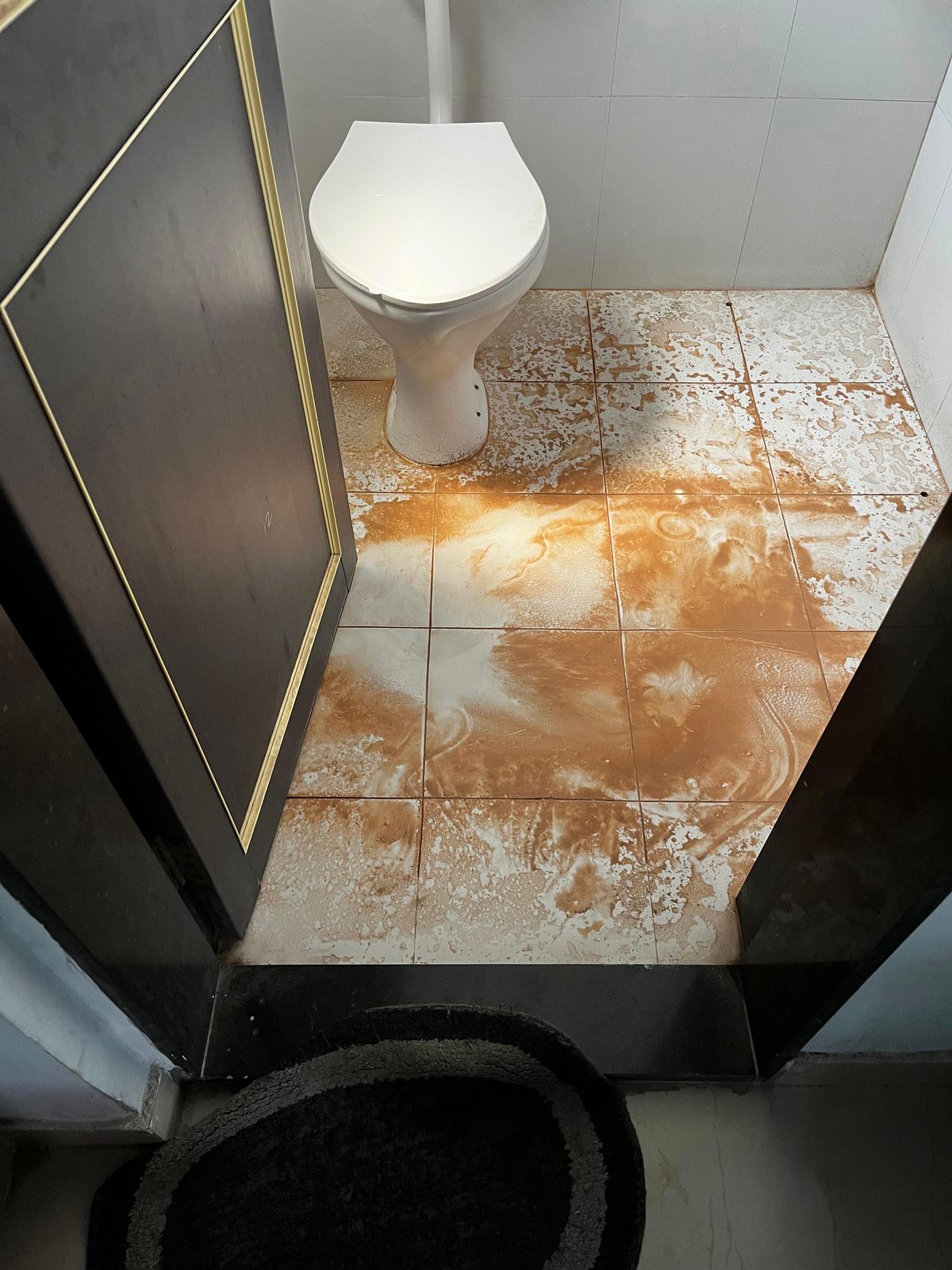 Before waterproofing: severe water damage, leaking tile joints, and efflorescence on bathroom floor