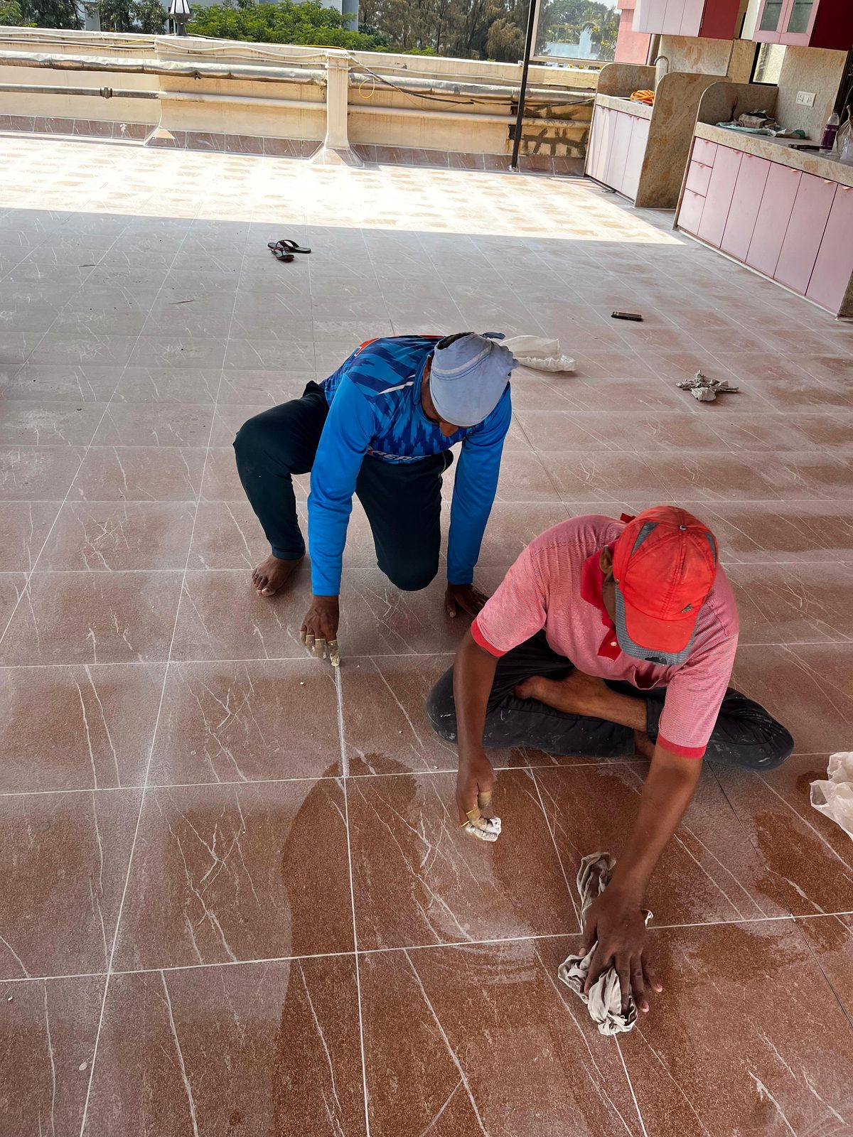 Waterproofing technicians grouting terrace tiles in Pune